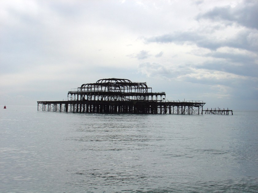 The rotting steel of a ruined pier end sits in the middle of the sea