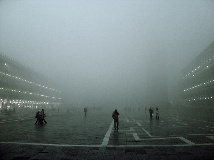 Silhouetted figures in St. Mark's Square in heavy mist