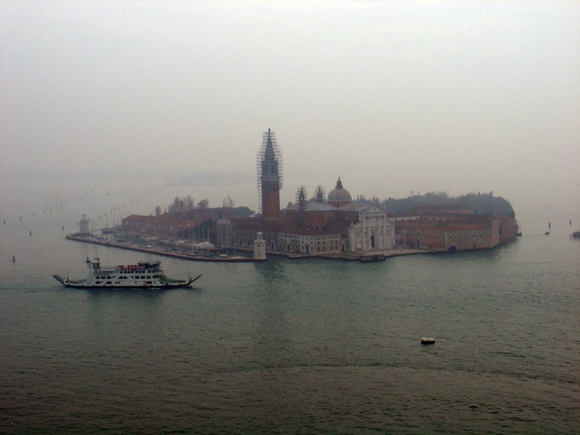 From above, the water surrounded Island with a church steeple covered in scaffolding