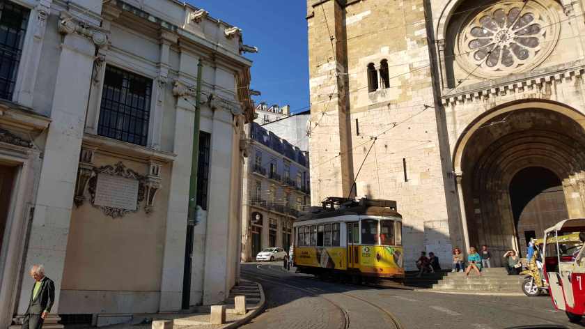 An old tram car tracks by an old stone cathedral