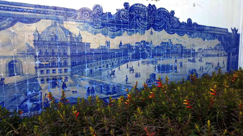 The tile mural in blue and white shows historical Lisbon scene