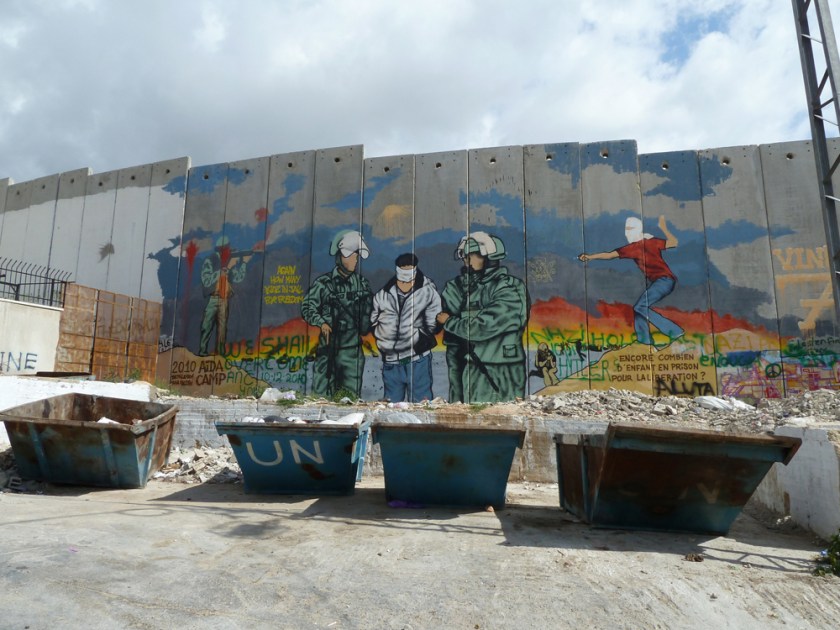 The separation wall painted with a mural of two army officers escorting a blindfolded prisoner