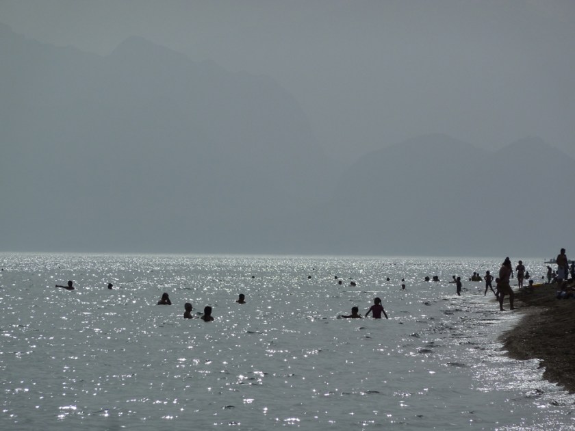 Swimmers silhouetted in the sea on a hazy day