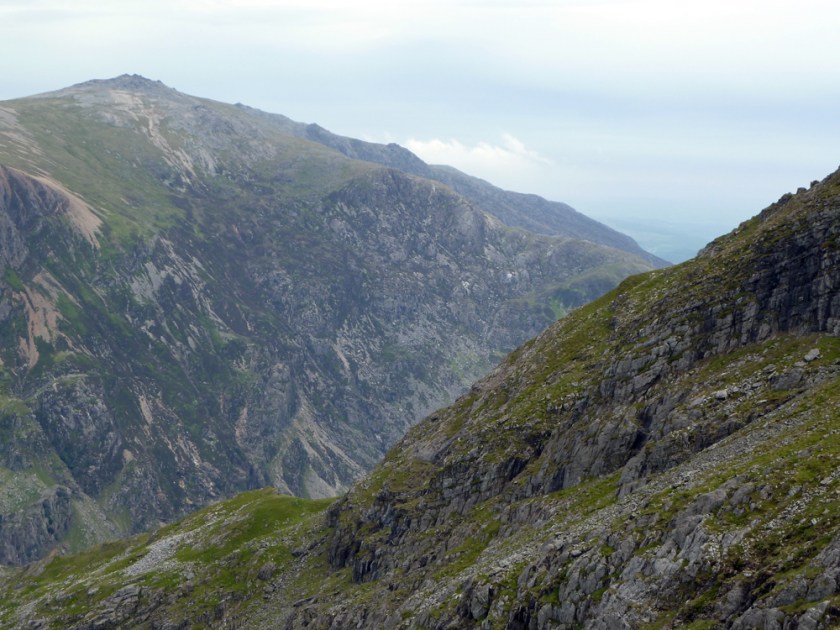 Two mountain peaks, stony grey with green moss