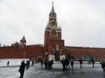 People mill around the Kermlin tower in Red Square in the snow