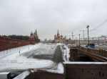Snowy landscape shows a bridge, and in the distance, the Kremlin and St. Basil's Catherdral