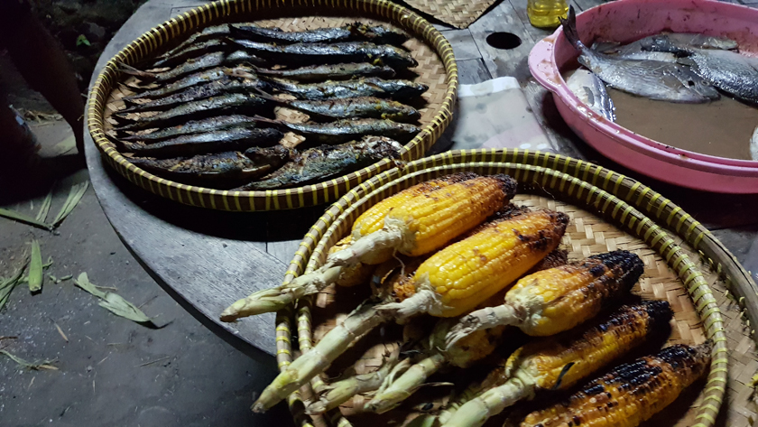 Baskets of grilled and charred corn on the cob and sardines
