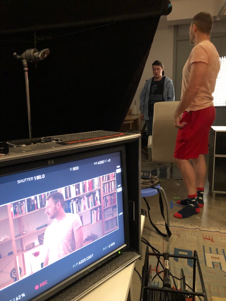 A TV monitor shows the shot of one actor on set.
