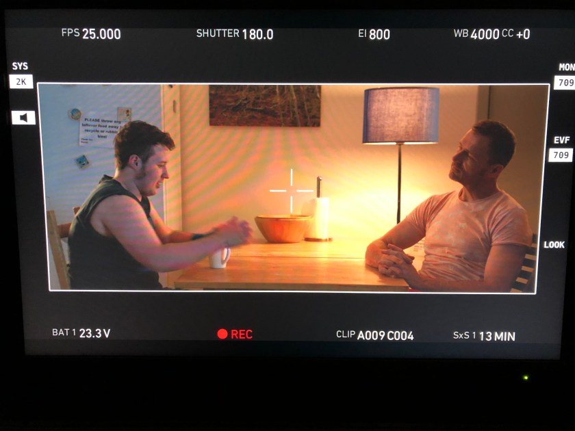 Two people sit across the table from each other.