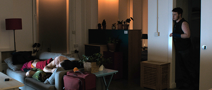 Orin looks over at the sofa where Anto sleeps in the light of the telly