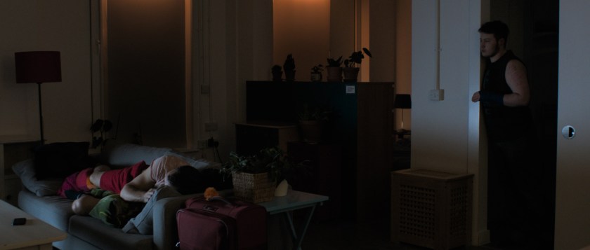 Anto sleeps on the sofa as Orin looks over from the bathroom
