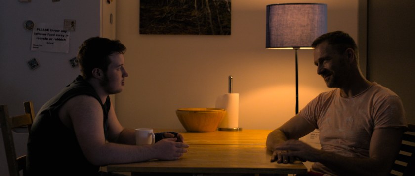 Orin and Anto sit across from each other at the dining table