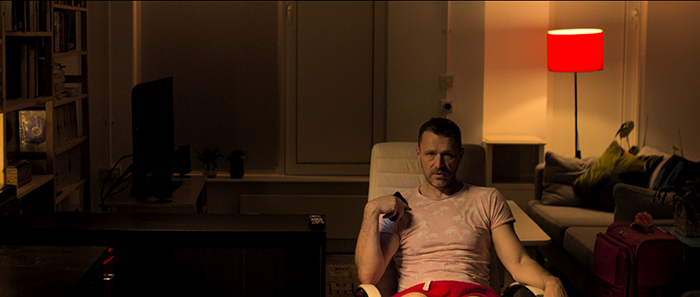 Anto, seated in lamplight, looks at us, surprised