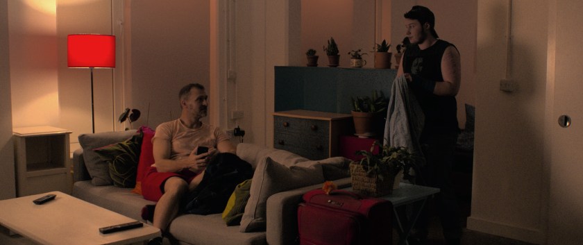 Ink holds their jacket about to leave as Anto sits on the sofa