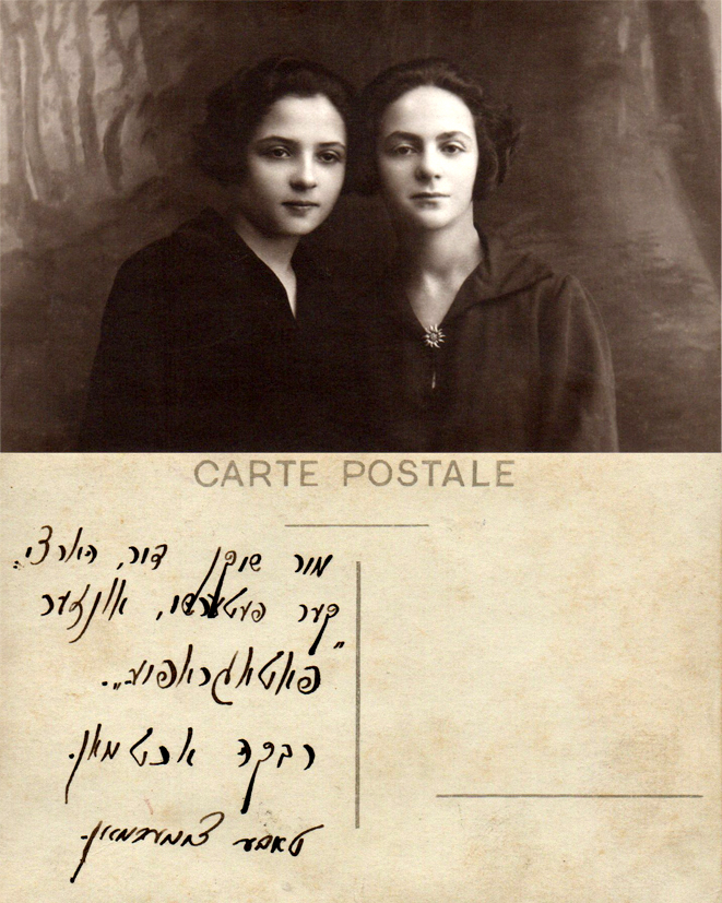 Sepia portrait of two young women seated close together, shown with the postcard reverse bearing a handwritten Yiddish inscription.